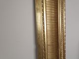 a mirror with a gold frame hanging on the wall