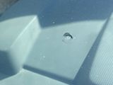 a hole in the windshield of a car that has a hole in it