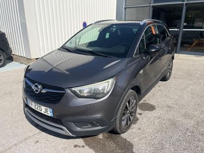 a grey opel parked in front of a building in a parking lot