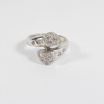 a close up of a diamond ring on a white surface
