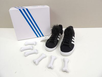 a pair of black and white shoes next to a box of bones