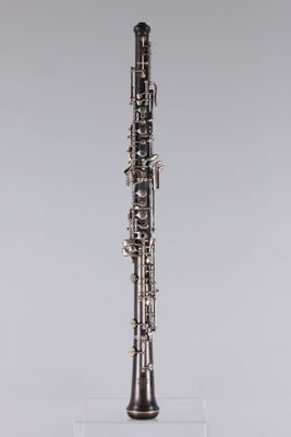 a clarinet with a silver body and black keys on a clear stand