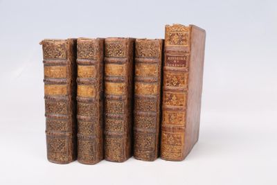 quatre vieux livres sont empilés les uns sur les autres sur une surface blanche