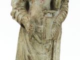 une vieille statue représentant un homme avec un chapeau et une canne