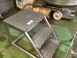 un tabouret métallique au milieu d'un sol vert