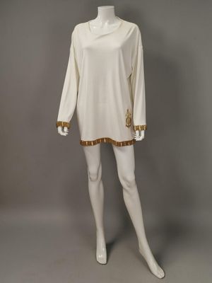 an image of a mannequin wearing a white dress with gold trims
