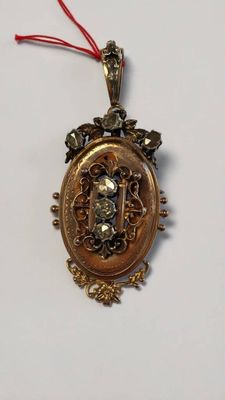 un pendentif en or sur lequel est gravé le portrait d'une personne