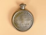 a silver pocket watch on a beige surface