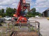 a crane that is sitting in the dirt near a building