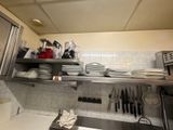 une cuisine où le plan de travail est encombré de vaisselle et d'ustensiles