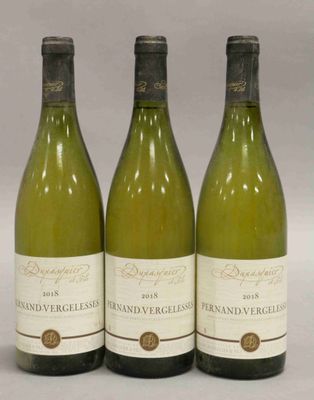 trois bouteilles de vin posées sur une table l'une à côté de l'autre