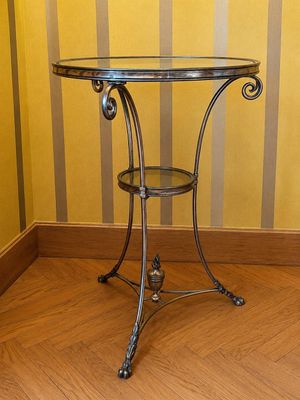 une petite table avec un plateau en verre posée sur un parquet