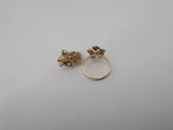 a pair of gold rings on a white surface