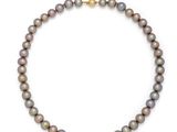a grey pearl necklace with a gold clasp on a white background