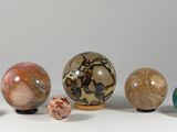 five different colored marbles sitting on a white surface