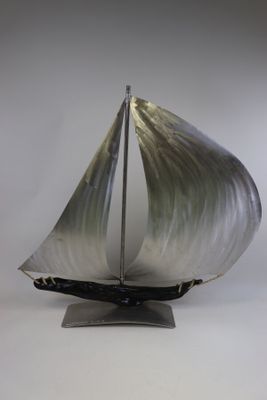 une maquette en métal d'un voilier posée sur un socle