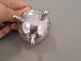 a person that is holding a silver object on a table