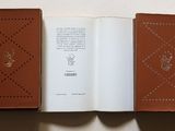 a book open on a white table with a brown cover