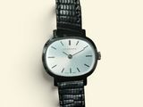 une image d'un gros plan d'une montre-bracelet sur une surface blanche