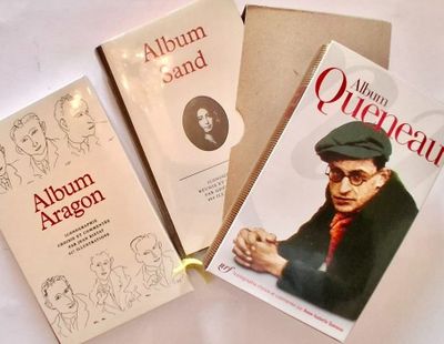 three books are sitting on a table with a white table cloth