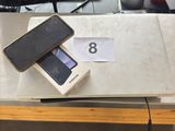 a cell phone sitting on top of a table next to a tv