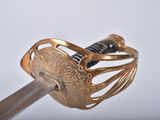 a close up of a gold colored sword with a black handle