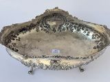 an antique silver plate with a decorative design on it
