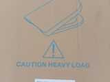 a cardboard box with a sign on it that says caution heavy load