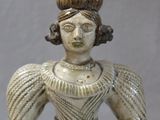 une statue représentant une femme en robe, posée sur une table