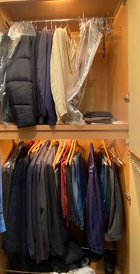 a closet with a lot of clothes and a coat rack