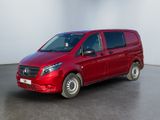 La camionnette rouge est garée dans une grande pièce aux murs blancs.