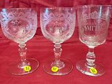 three empty wine glasses sitting next to each other on a red cloth