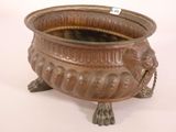 a large bronze pot with a lion head on it