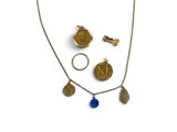 un gros plan d'un collier, d'une bague et d'autres objets posés sur une surface blanche