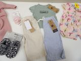 a lot of baby clothes and shoes on a table