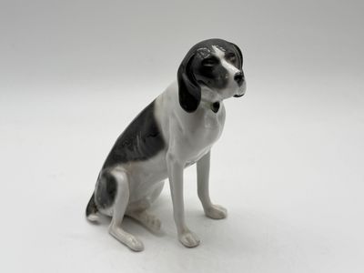 a black and white dog figurine sitting on a white surface