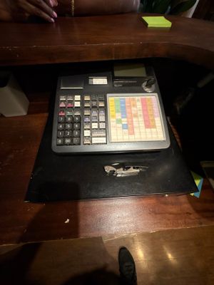 une personne assise à un bureau sur lequel se trouve une calculatrice
