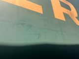 a green and yellow sign on the side of a building