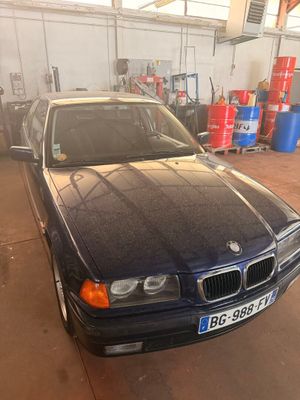 une voiture noire garée dans un garage à côté d'autres voitures