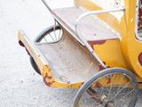a small yellow car that is parked on the side of the road
