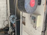 an image of a garage with a water heater and a checkered floor