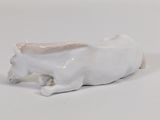 porcelain figurine of a cow laying down on a white surface