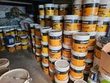 many buckets of paint stacked on top of each other