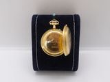 an image of a gold pocket watch with a blue velvet case