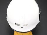 a close up of a white hard hat on a yellow glove