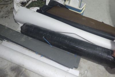 plusieurs rouleaux de plastique noir et blanc posés sur un sol en béton