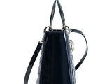 the small black bag is sitting on a white surface