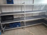 many shelves in the room with blue bins on them