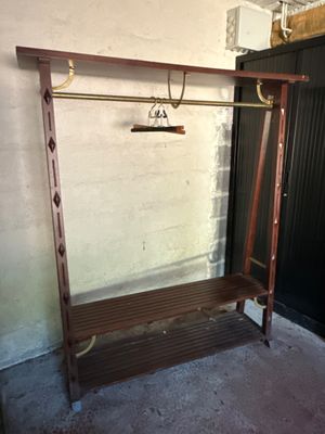 a coat rack with a coat hanger on it in the corner of a room