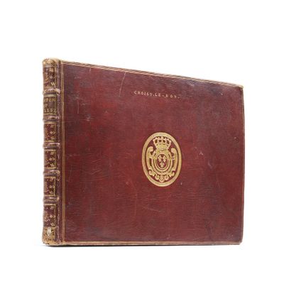 an old book with a gold emblem on the cover